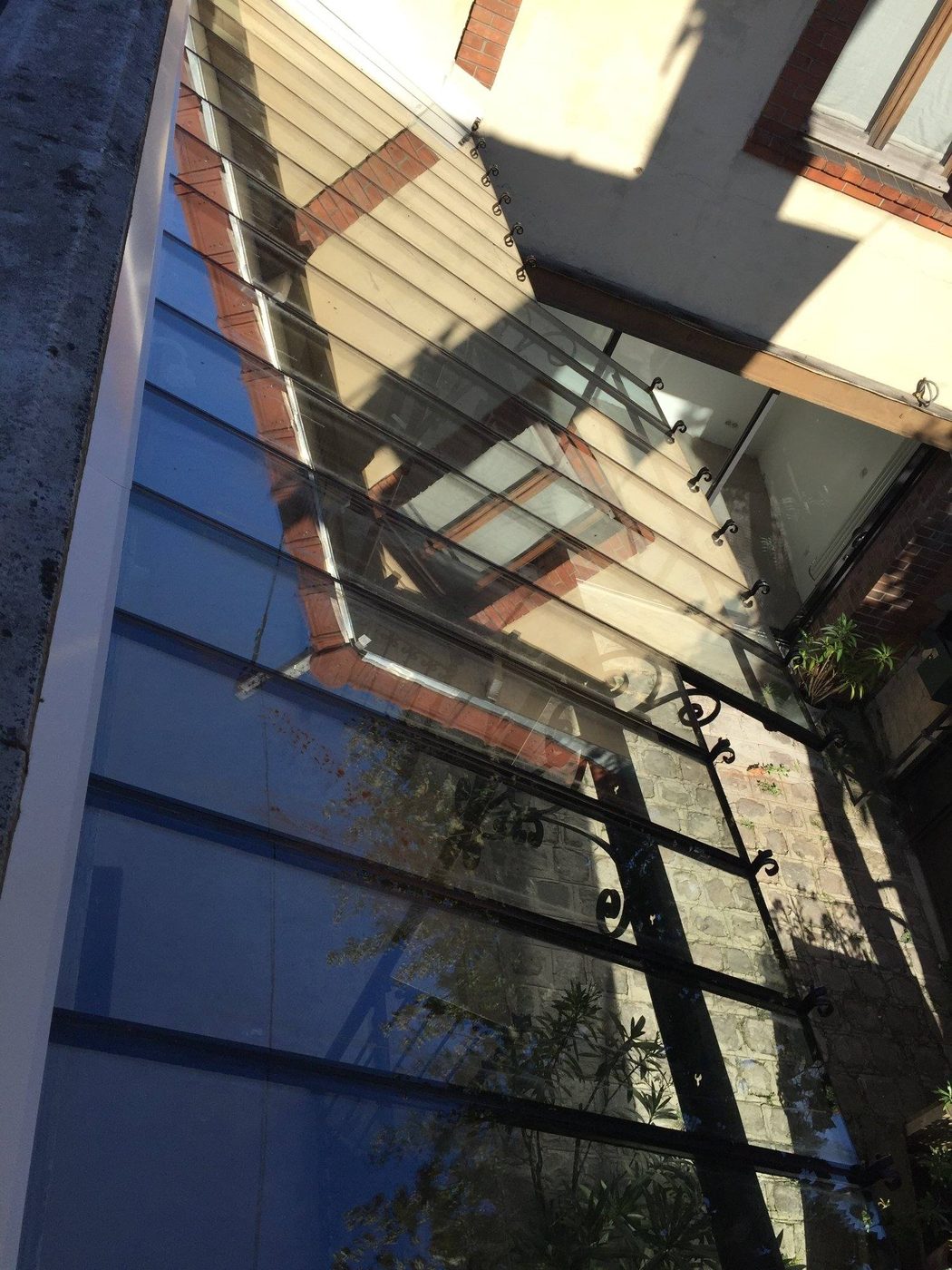 Auvent vitré à structure noire en fer forgé, après rénovation — EloxyMetal