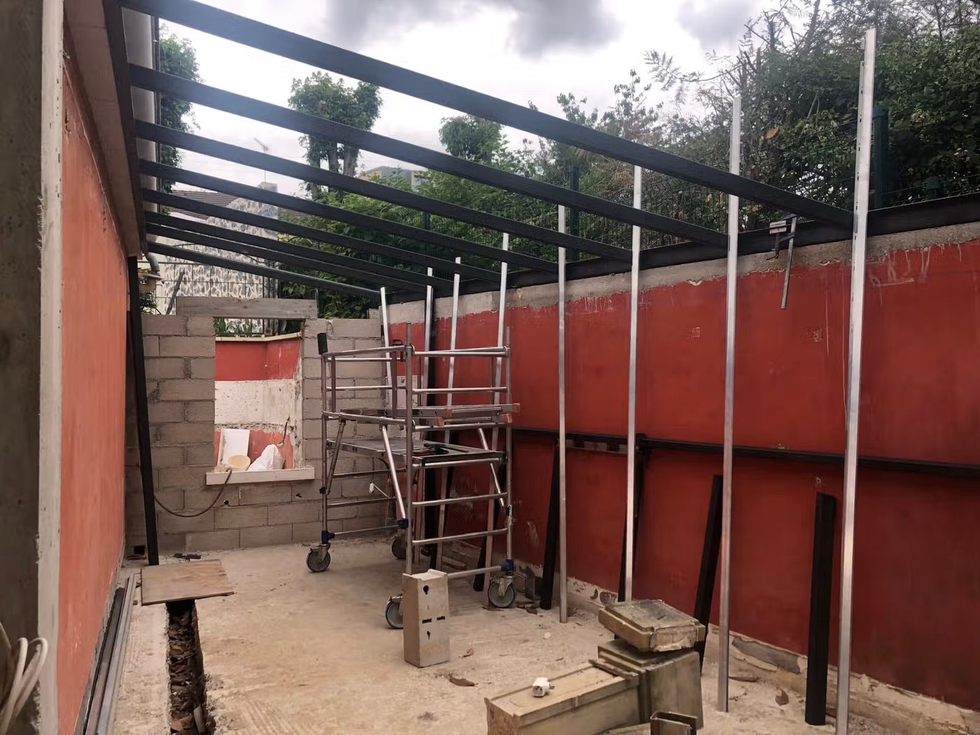 Pergola métallique en acier noir en construction sur une extension — EloxyMetal