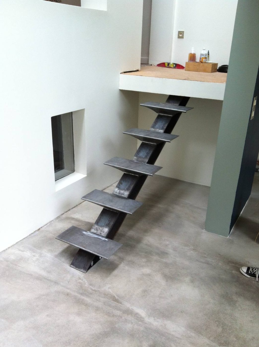 Escalier à limon central en acier brut desservant une mezzanine — EloxyMetal