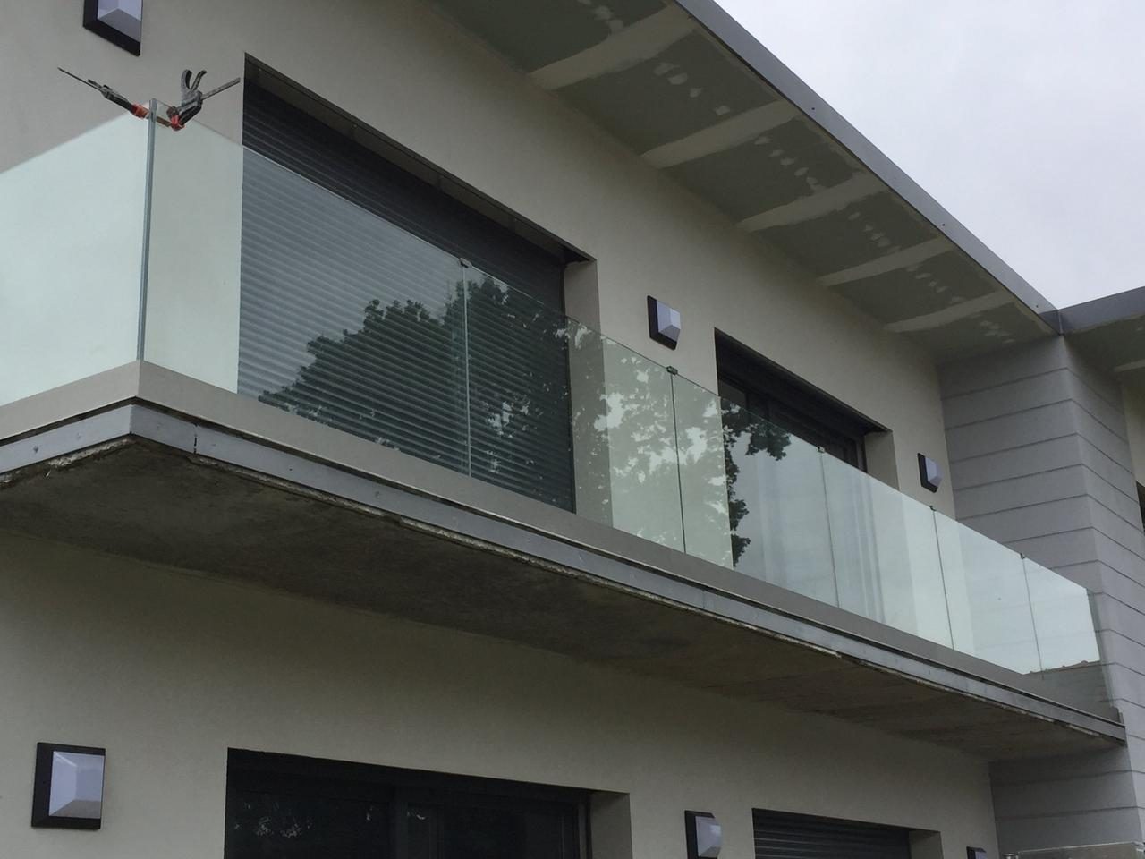 Garde-corps en verre trempé sur palier d'étage, sabots inox sur parquet — EloxyMetal