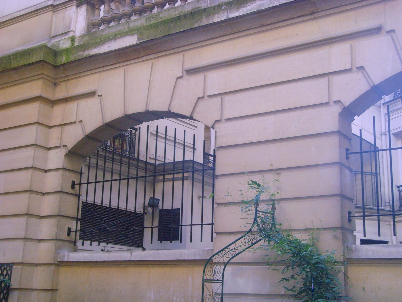 Grille de sécurité en fer forgé sous l'arcade d'un immeuble haussmannien — EloxyMetal