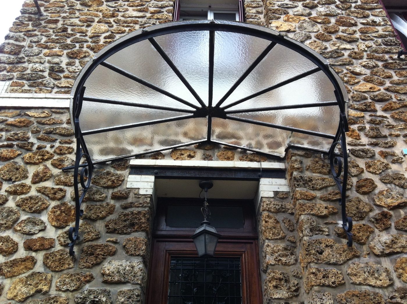 Marquise demi-lune en fer forgé et verre armé sur façade en meulière — EloxyMetal