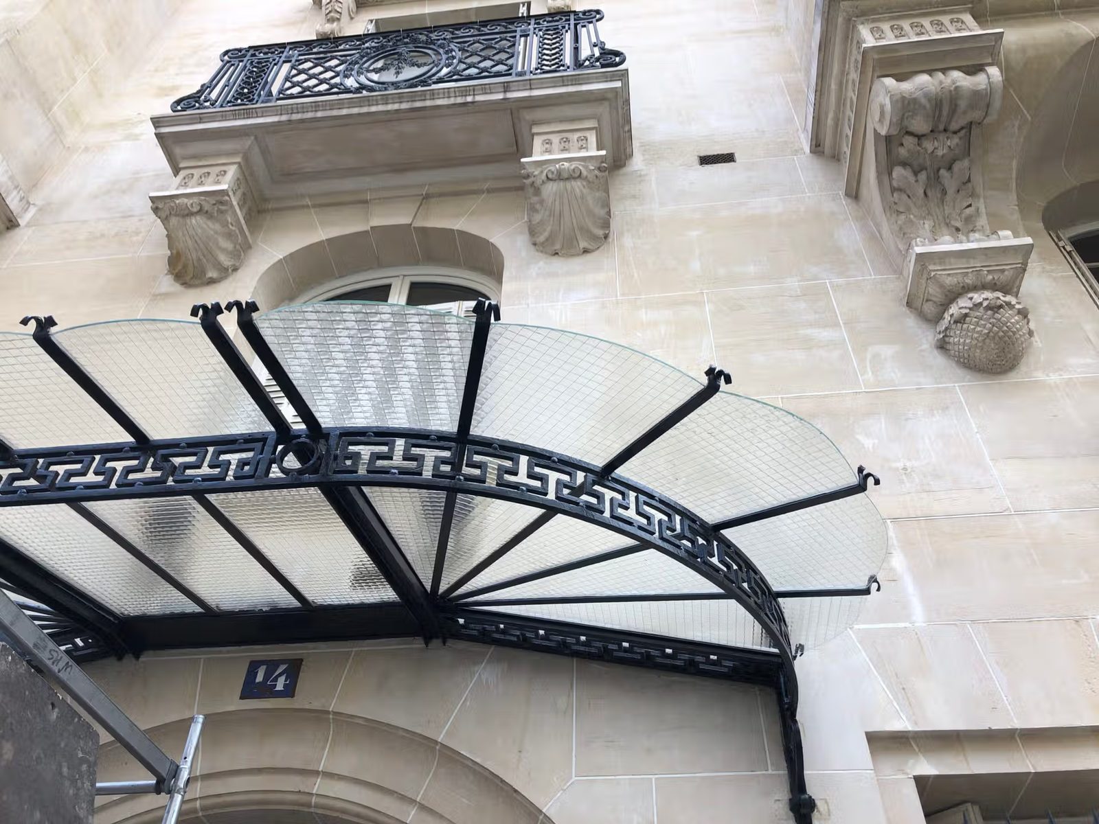 Marquise entrée fer forgé vitrage cathédrale immeuble haussmannien Paris