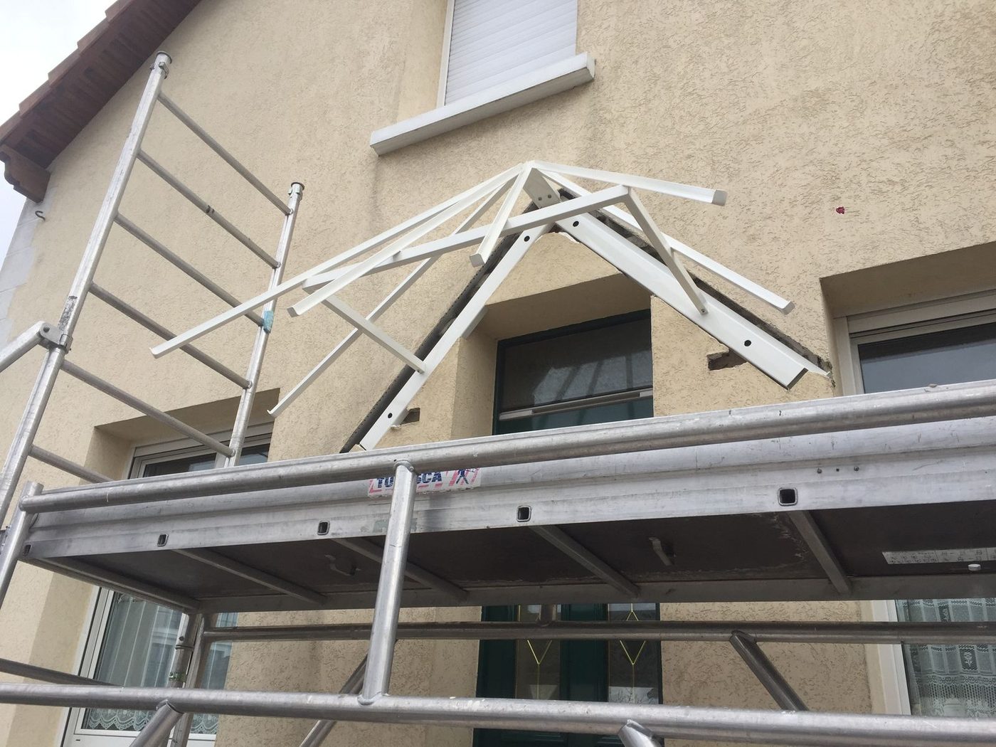Structure acier de marquise en cours de pose sur façade