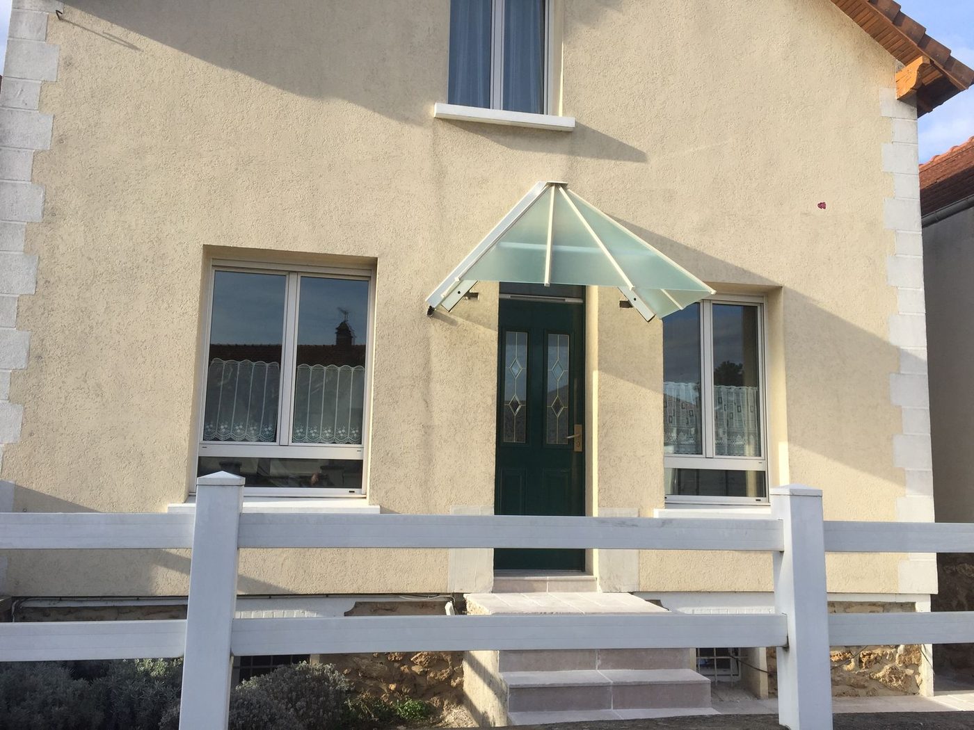 Marquise verre dépoli structure acier blanc au-dessus d'une porte d'entrée