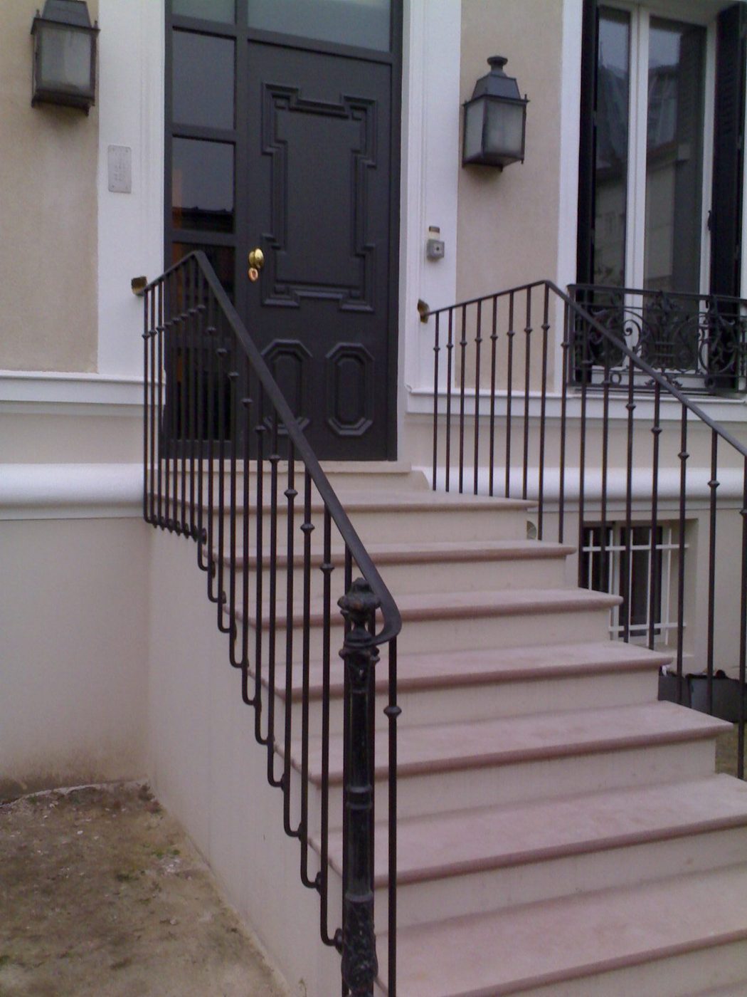 Rampe d'escalier en fer forgé devant un immeuble haussmannien — EloxyMetal