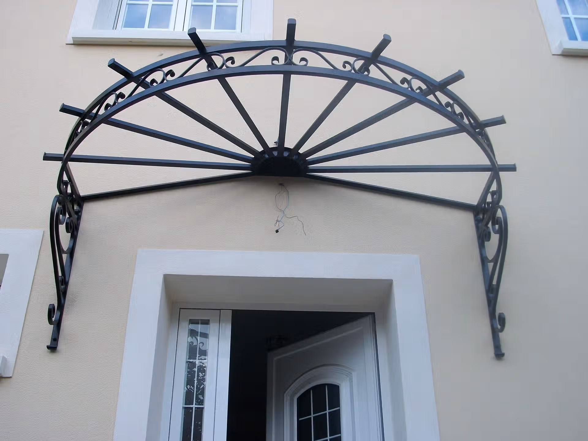 Marquise demi-lune en fer forgé avec consoles ornementées – Auvent décoratif entrée de maison – EloxyMetal Pithiviers